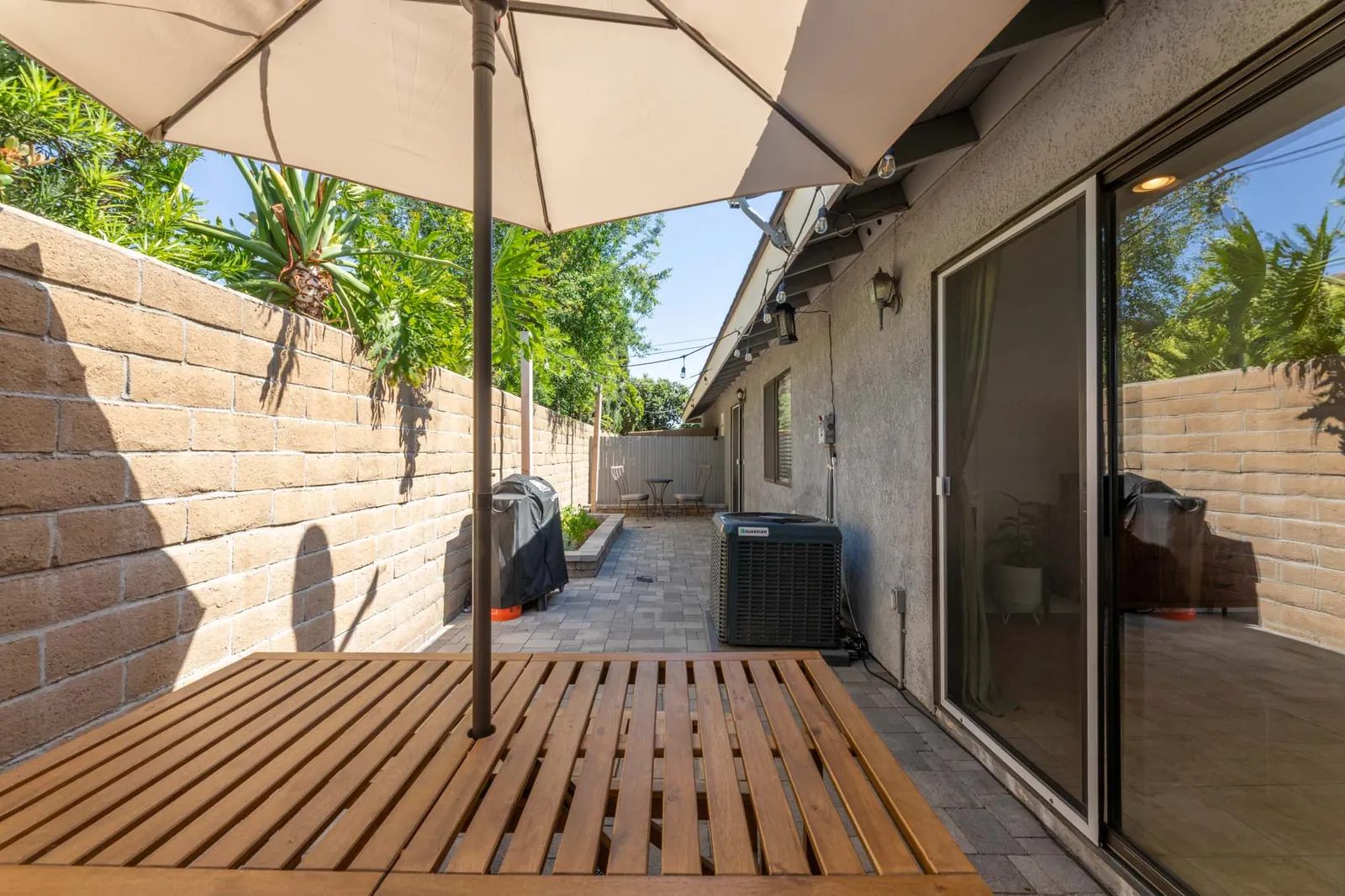 Private patio with wood deck and umbrella