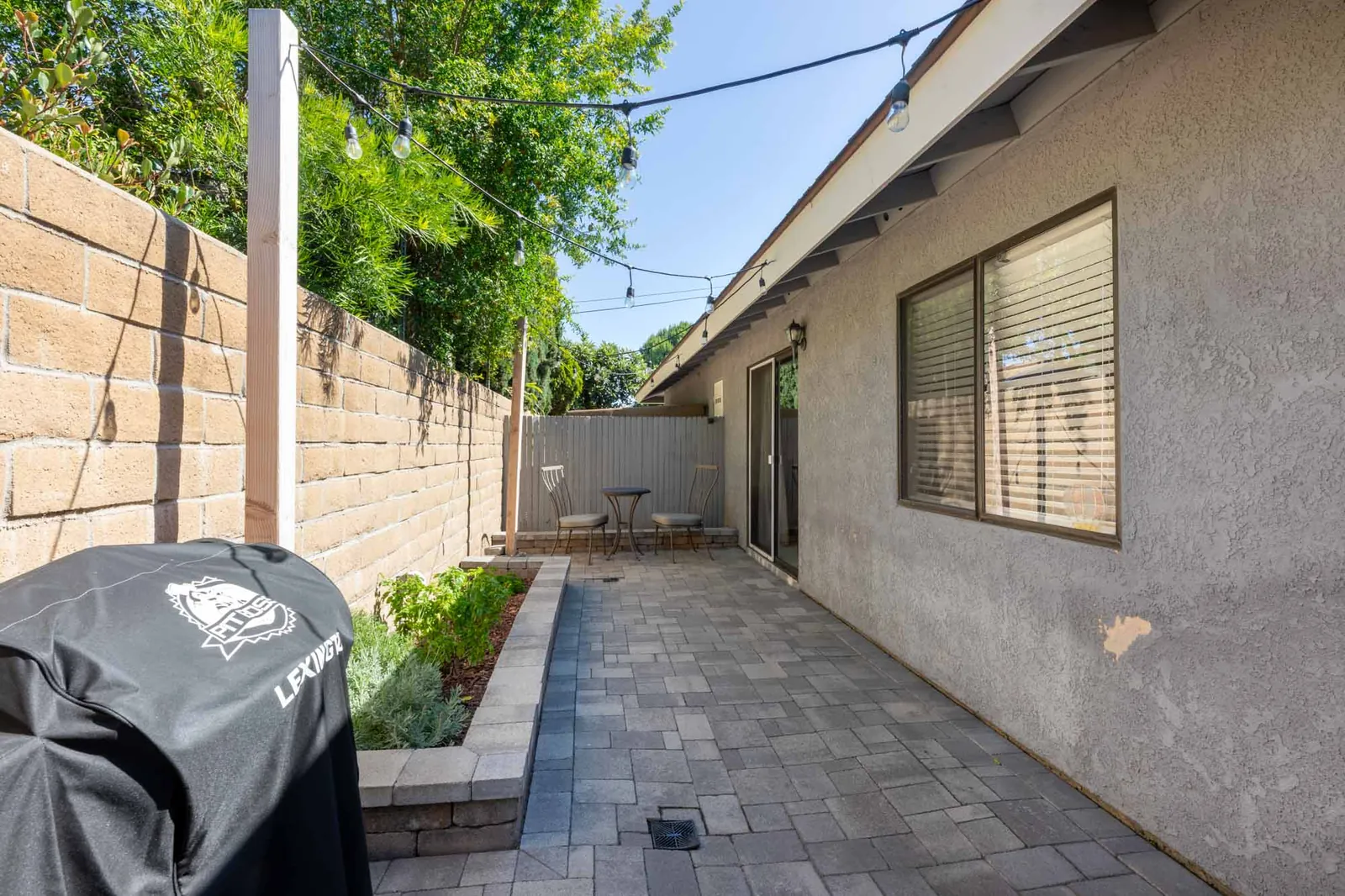 Private patio with paver hardscape and string lights
