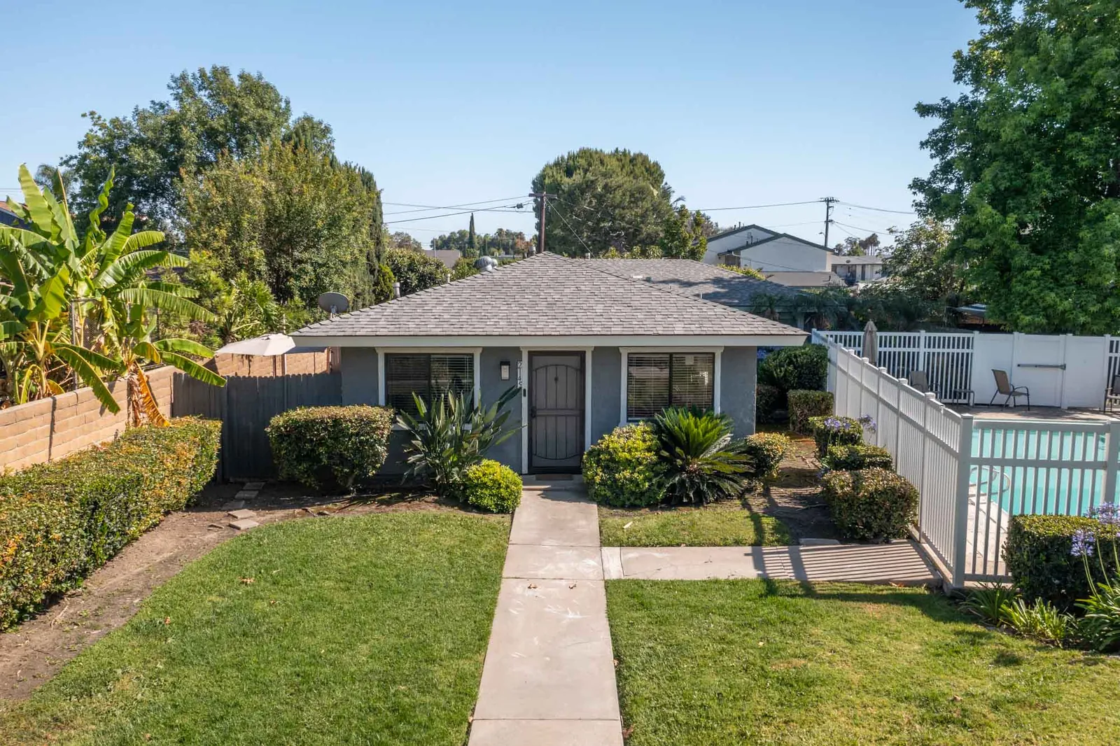 Front walkway with the community pool fence at right